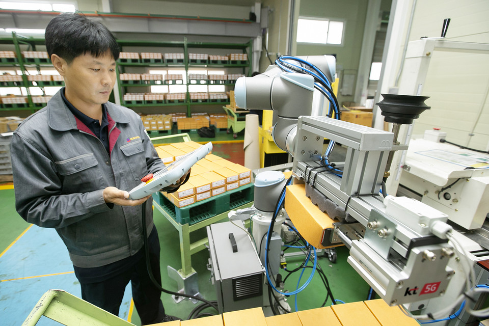 박원 공장에서 생산직 근로자가 KT 5G 스마트 팩토리 코봇과 함께 작업하고 있다. [사진=KT]